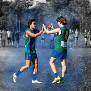 Two players celebrating a goal with a double hi-five